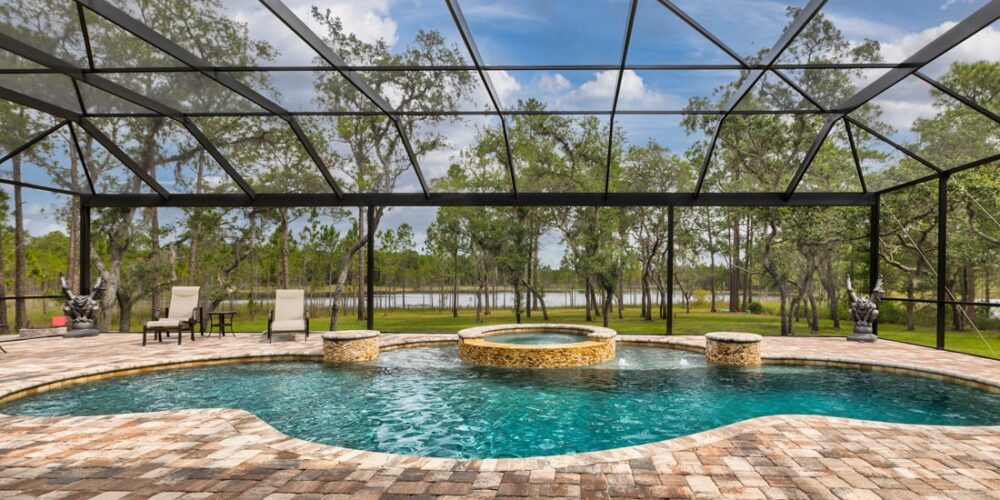 free form pool with integrated whirlpool spa covered shown inside spacious screen enclosure