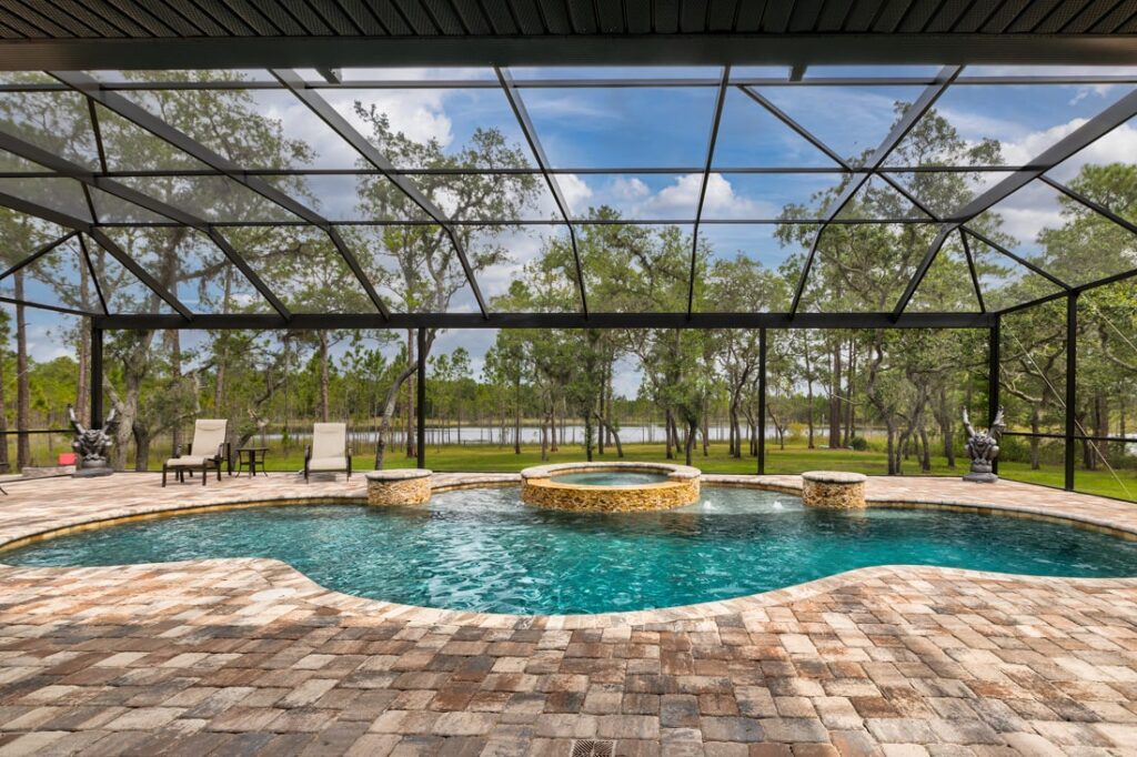 free form pool with integrated whirlpool spa covered shown inside spacious screen enclosure