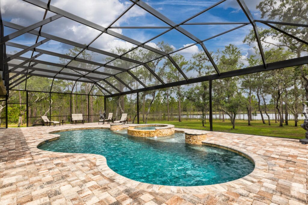 built in pool with curved border and integrated hot tub enclosed within screen canopy