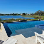 geometric tiled pool with integrated spa with view of nearby lake